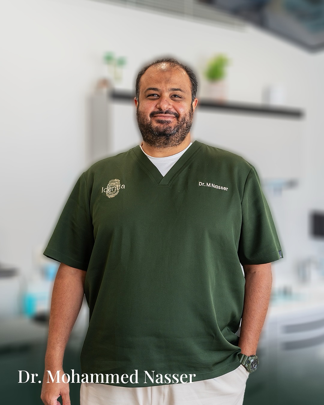 Portrait of Dr. Mohammed Nasser in green Identia scrubs against a soft clinic background.