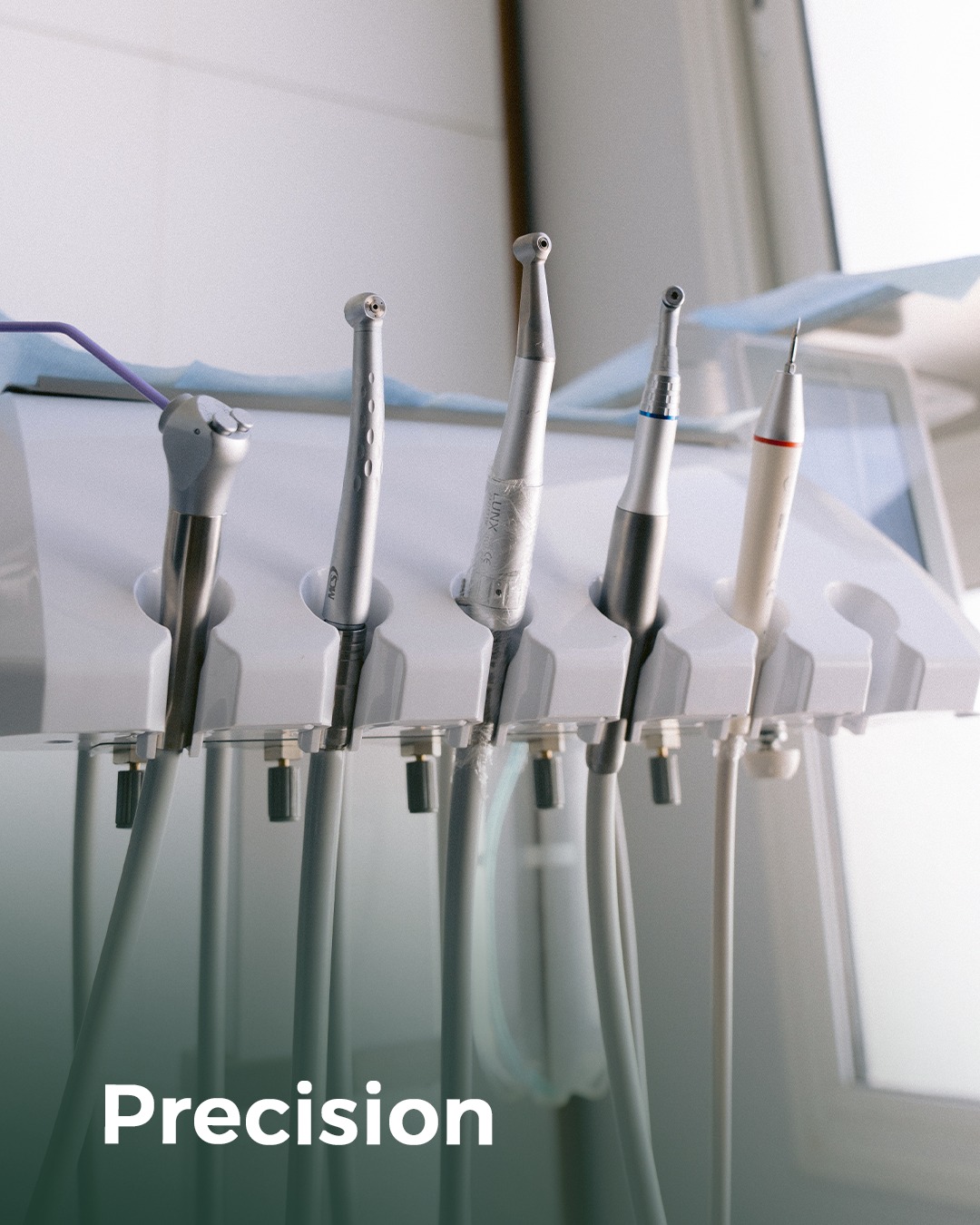 Detail of a modern dental handpiece on a sterile drape.